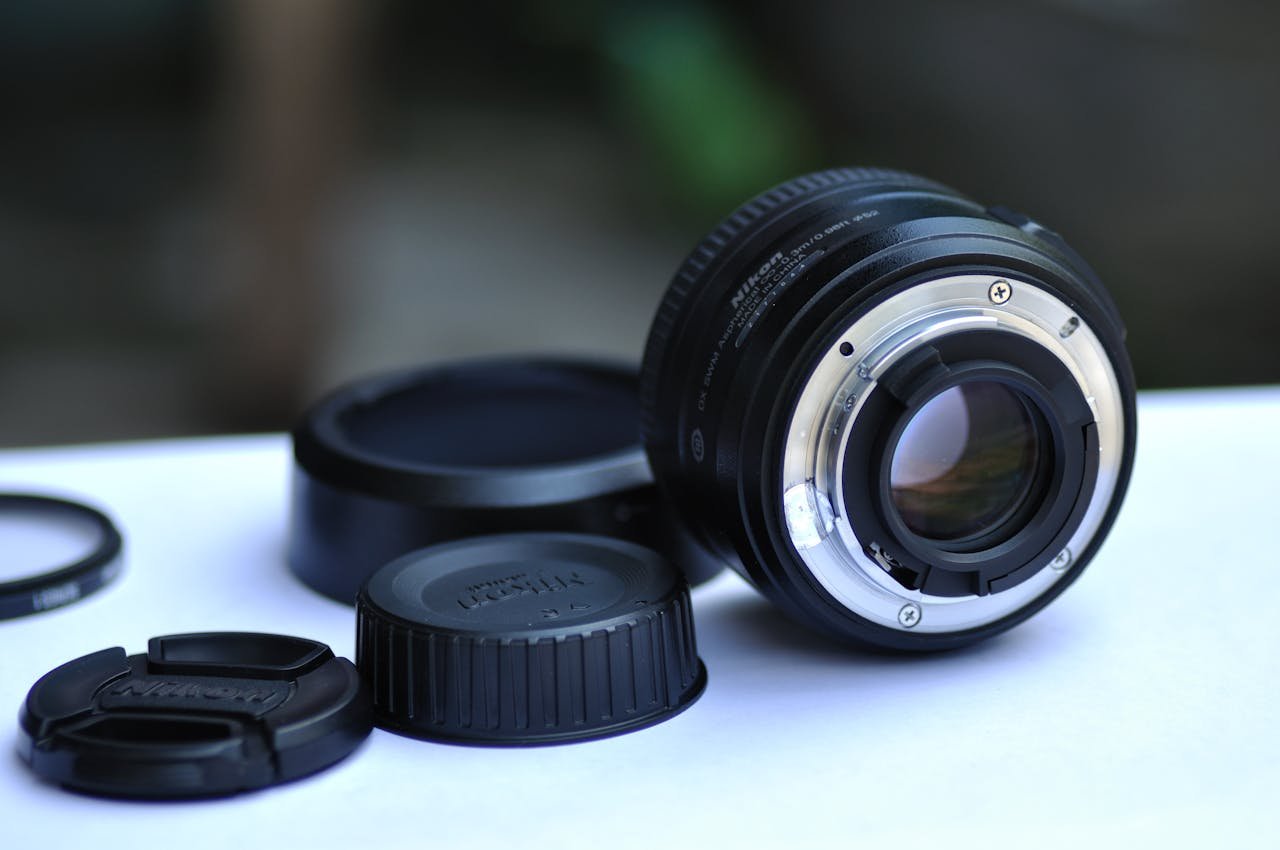 Detailed image of a camera lens with caps and accessories on a table.